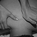 Image of hands pressing on a back, depicting Swedish massage